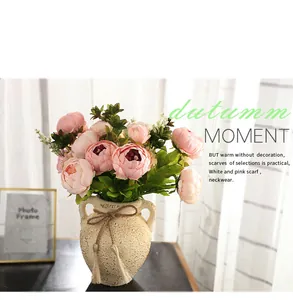 Detailed close up view of artificial peony flower bouquet in vintage ceramic vase home decor.