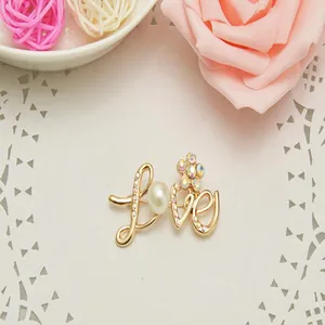 Exquisite LOVE letter rhinestone brooch for women, stylish gold alloy fashion jewelry.