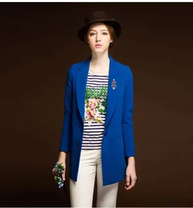 Vue de detail broche sapin de Noel en cristal sur blazer bleu, accessoire de mode tendance.