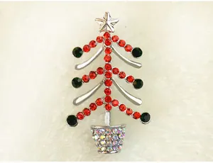 Détail de broche sapin de Noël en strass étincelants, épingles cristaux rouges verts.