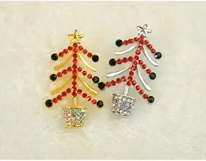 Gros plan detail des jolies broches sapin de Noel en strass aux finitions dorees et argent.