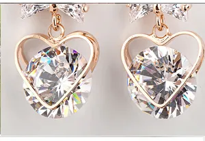 Close-up detail of rose-gold plated heart earrings with sparkling cubic zirconia crystals.