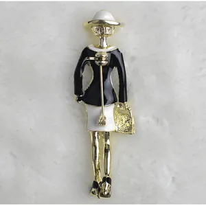 Elegante Damen Brosche aus Emaille in Goldoptik mit schwarz-weißen Kleidung für Accessoires.