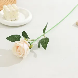 Detailed shot of single artificial rose flower with realistic petals and long green stem.