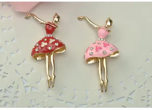 Close-up detail of rhinestone ballerina brooches in red and pink dresses on elegant background.