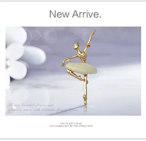 Close-up detail of exquisite rhinestone ballerina brooch with elegant enamel tutu and gold alloy.