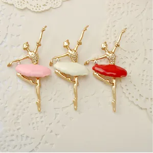 Close-up detail shot of three elegant ballerina brooches with colorful enamel tutus and rhinestones.