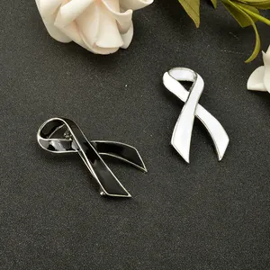 Closeup of black and white enamel ribbon brooch, elegant zinc alloy pin detail shot.