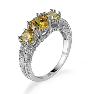 Eleganter silberfarbener Ring mit drei gelben Zirkonia Steinen und funkelndem Pavé-Band.