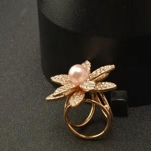 Vista detallada de una hebilla de bufanda con flor de diamantes de imitación y perla rosa.