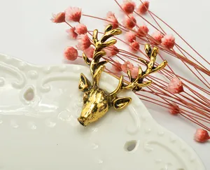 Detailed close-up of a vintage gold deer head brooch, antique finish ornament for clothing.