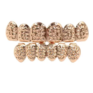 Gold hip hop grillz detailed view, textured metal teeth grill for party and costume styling.