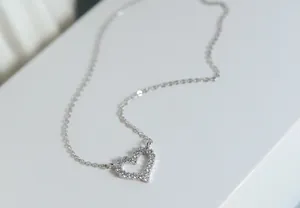 Detailopname van een 925 sterling zilveren hartketting met fonkelende zirkonia's.