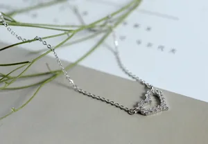 Macrodetail van een 925 sterling zilveren ketting met glinsterende hartvormige hanger.