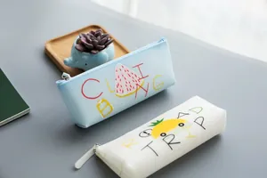 Close up detail of cute triangular silicone pencil pouch with fruit graphic and zipper closure.