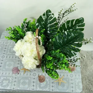 Vue détaillée de faux monstera et fleurs blanches en pot avec panier tressé pour décoration.