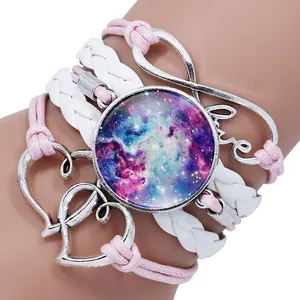 Macro view of pink and white braided bracelet with galaxy gem and heart charms