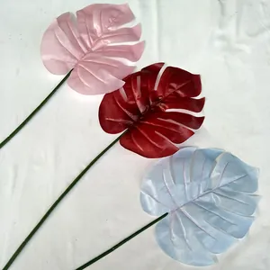 Détail de feuille de monstera artificielle, fausse plante colorée pour déco et fleurs.