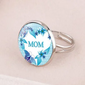Macro detail of a silver-toned adjustable ring featuring a blue floral heart and MOM text