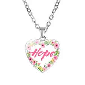 Vista detallada de collar con colgante de corazón, texto 'Hope' y corona floral