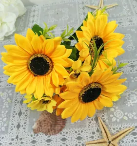 Détail du bouquet de tournesols artificiels aux pétales jaunes et belles feuilles.