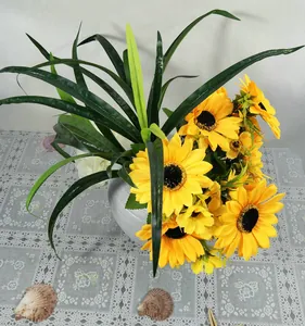 Gros plan détaillé d'un bouquet de tournesols artificiels vibrants dans un pot blanc.