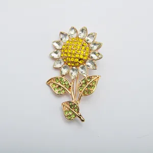 Detailed close-up of a vintage sunflower brooch featuring yellow and green rhinestones