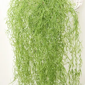 Primer plano detallado de planta de aire artificial colgante, textura de hojas verdes rizadas.