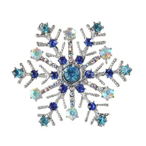 Detailed close-up of silver tone snowflake brooch featuring sparkling blue and iridescent crystals.