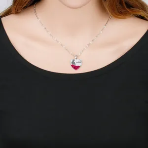 Detailed view of a silver heart pendant necklace with red roses and Mom engraving
