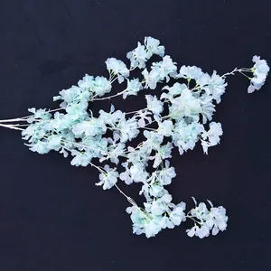 Detail van kunstmatige sneeuwkersbloesem tak, witte stengel bloemdecoratie voor huwelijk boog