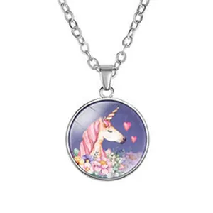 Close-up of circular unicorn pendant necklace with pink hearts and flowers