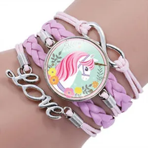 Detail view of a handcrafted multilayer pink unicorn bracelet with infinity Love charms.