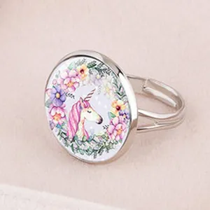 Detail view of a silver adjustable ring featuring a colorful unicorn and floral motif.