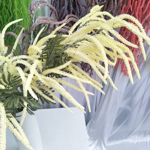 Detailansicht künstliche Blumen, gelbe und grüne Astilbenzweige in weißer Deko-Vase.