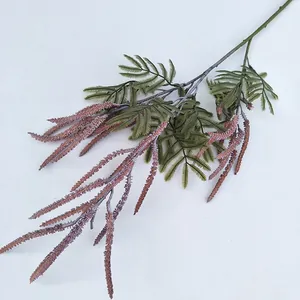 Detailansicht eines künstlichen Pflanzenzweigs mit grünen Blättern und rosa Blütenständen.