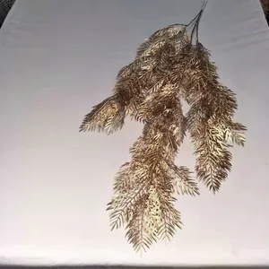 Guirnalda de agujas de pino artificiales doradas para decoración de bodas, primer plano.
