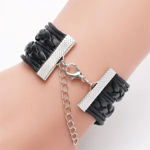 Detail view of a black multi-layer braided bracelet with a silver lobster clasp and chain.