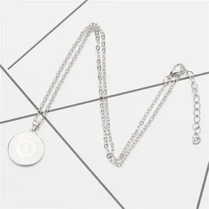 Detailed view of the silver-tone necklace with a radial sunburst round pendant.