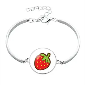 Detailed view of a silver-toned bangle with a cute red strawberry pendant charm.