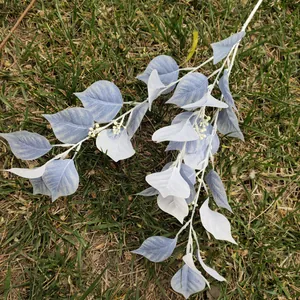 Artificial blue leaf plant branch detail shot, natural grass background display style.