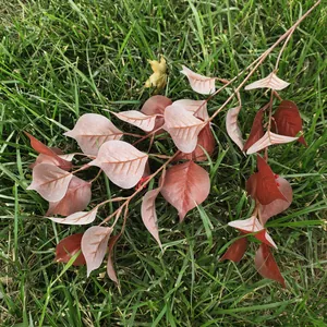 Detailed shot of artificial red bodhi leaf branch, vibrant gradient colors for home decor.