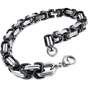 Macro detail of two-tone black and silver stainless steel Byzantine chain necklace for men