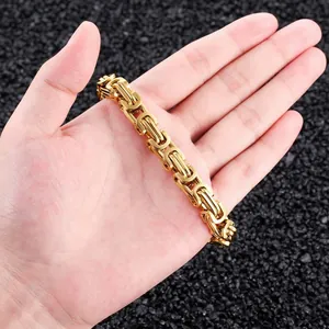 Macro detail of a thick gold-plated stainless steel Byzantine chain bracelet on a hand