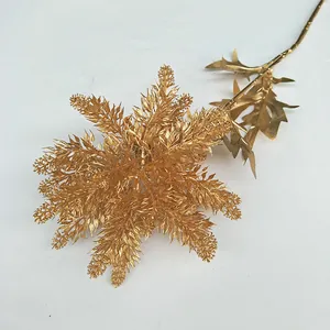 Golden artificial plant detail branch with metallic gold leaves for festive wedding decor.