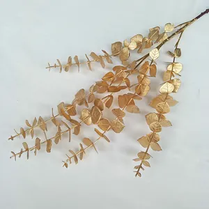 Close-up detail of golden artificial eucalyptus branch for wedding and event floral decor.