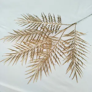 Gold artificial plant branch detail, metallic leaf decor for wedding floral display.