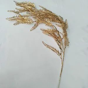 Golden artificial fern leaf detail view, perfect for wedding decoration and floral arrangements.