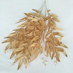 Gold artificial plant leaf detail shot, wedding decoration display branch, fake foliage.