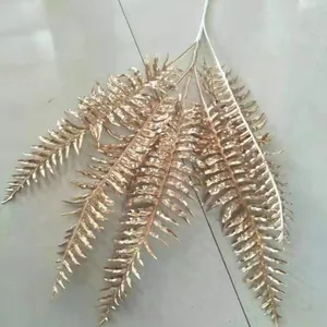 Gold artificial fern branches for wedding decoration, faux plant leaves for home display.